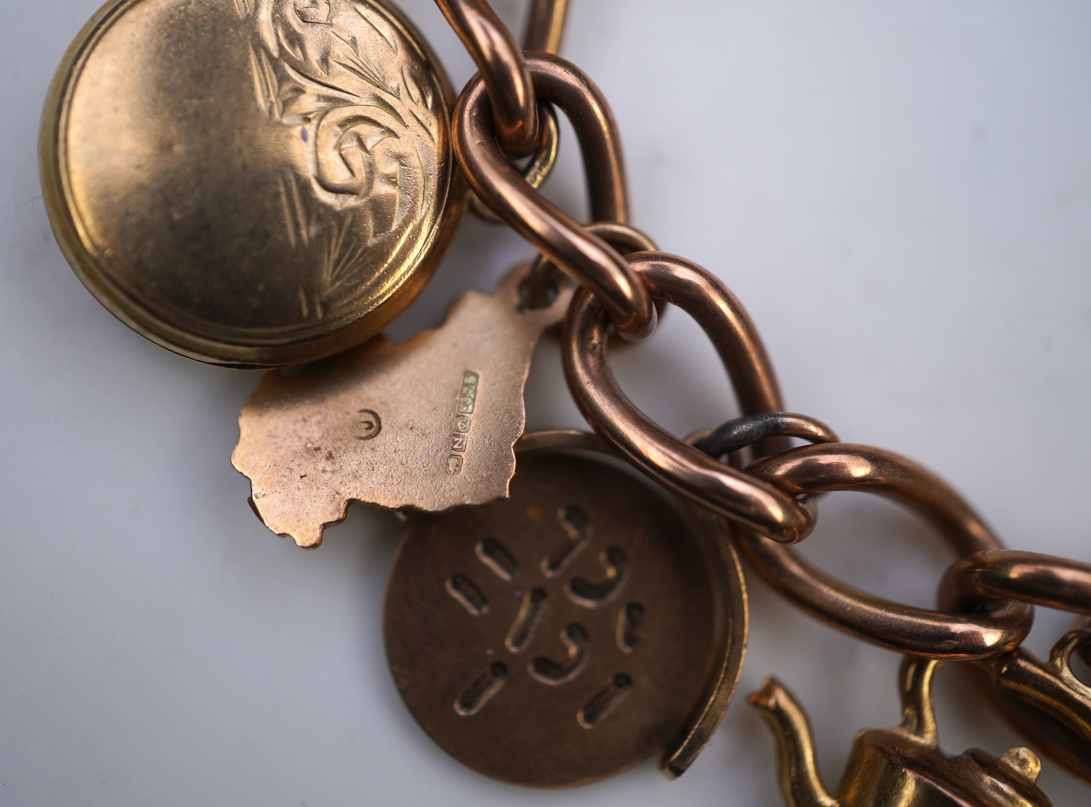 A gold charm bracelet, mid 20th century